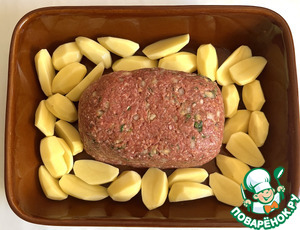 Мясной хлебец в окружении ломтиков картофеля