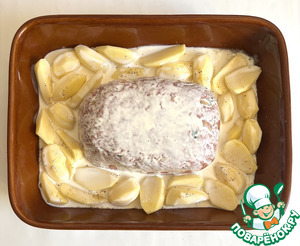 Мясной хлебец в окружении ломтиков картофеля